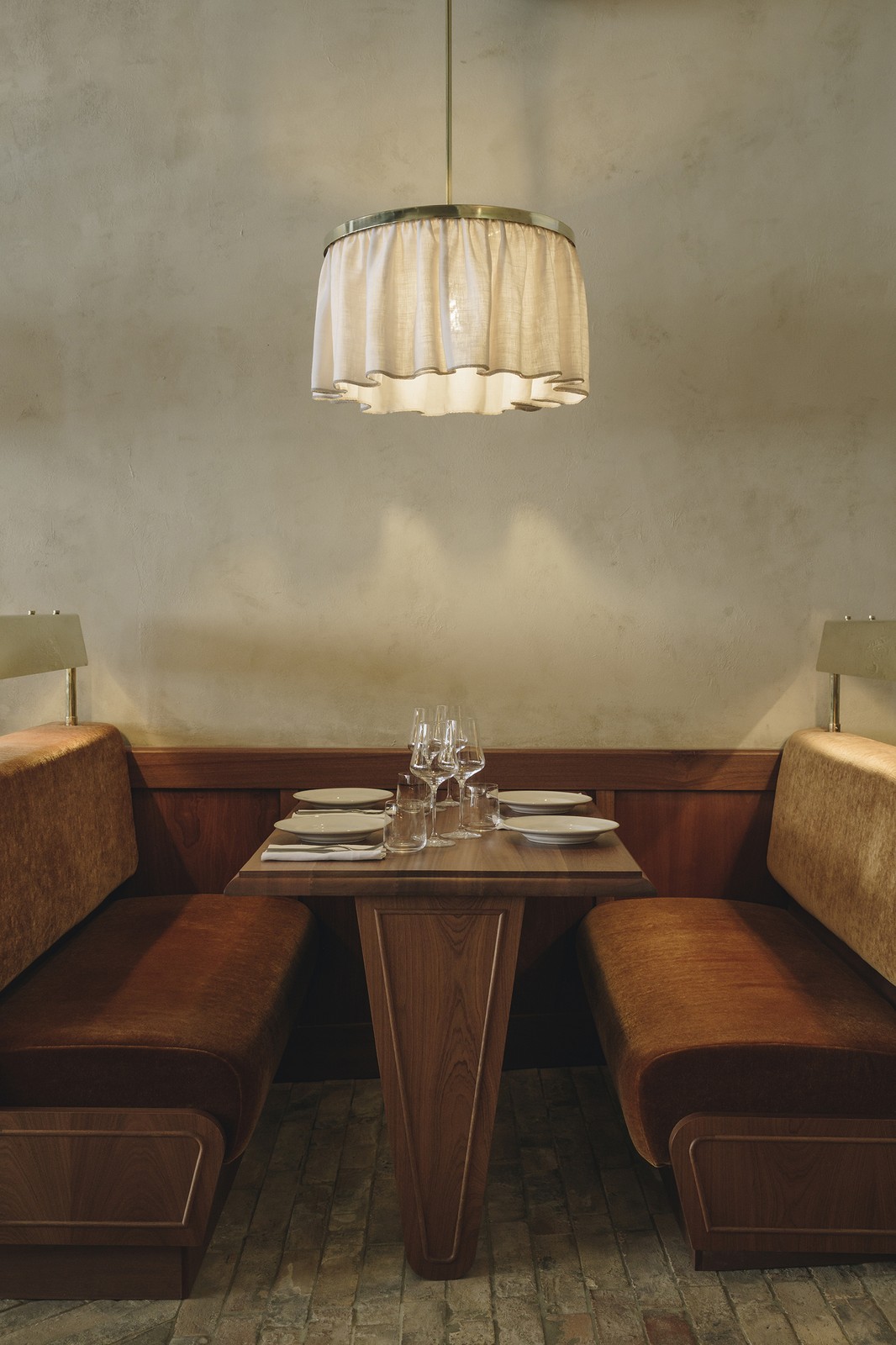 餐廳主廳長椅覆以溫暖的血橙色馬海毛，中世紀現代餐椅和深綠窗簾呼應整體空間的暖意